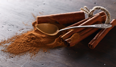 cinnamon sticks and powder on a old wooden table