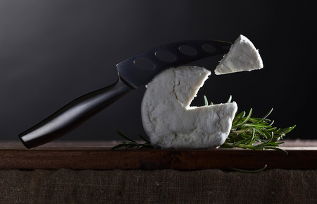 Fresh homemade goat cheese with rosemary and cheese knifeの写真素材