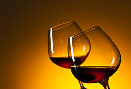 Glasses of brandy on a yellow backgroundの写真素材