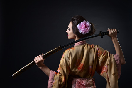 young beautiful woman in traditional Japanese kimono with katanaの写真素材
