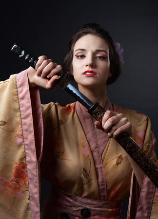 young beautiful woman in traditional Japanese kimono with katanaの写真素材