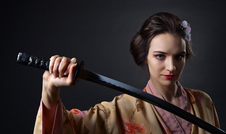 young beautiful woman in traditional Japanese kimono with katanaの写真素材