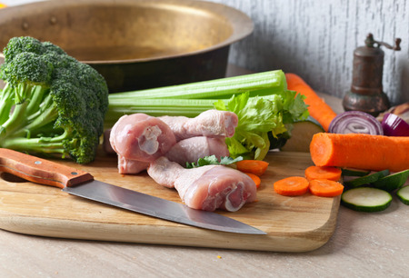 Close-up of raw vegetables with chicken drumsticks