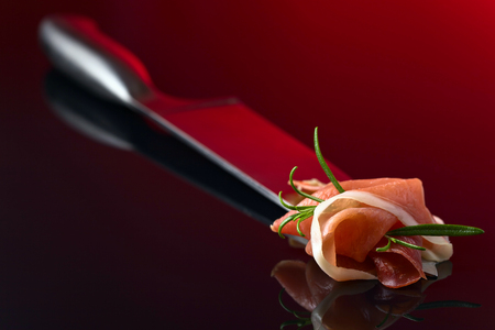 Prosciutto with  rosemary  on a reflective backgroundの写真素材