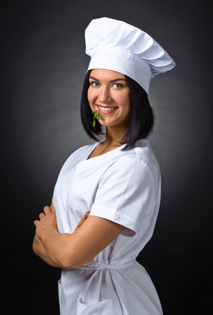 young woman in chef uniform with parsleyの写真素材