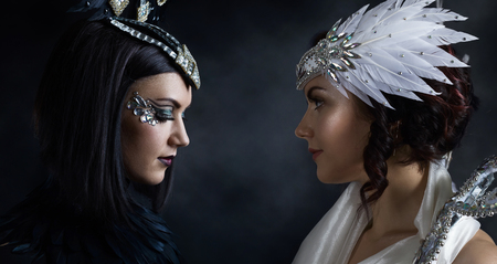 Young beautiful woman in costume black and white angel on black backgroundの写真素材