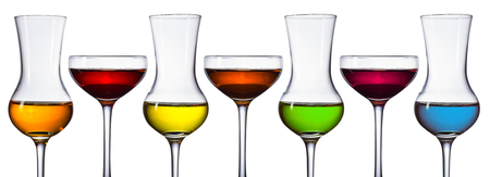Glasses of different alcoholic drinks isolated on a white background . Blue , green , yellow , orange and different shades of red .の写真素材