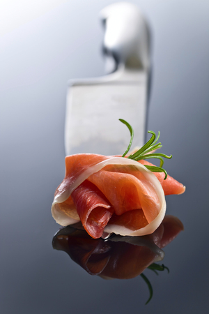 Prosciutto with  rosemary  on a big meat knife. Healthy eating , Mediterranean cuisine .の写真素材