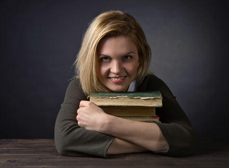Portrait of young happy woman with old books .の写真素材
