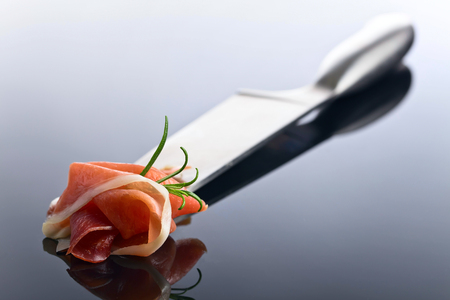 Prosciutto with  rosemary  on a reflective backgroundの写真素材