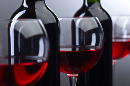 Bottles and glasses of red wine on a dark background . Selective focus .の写真素材