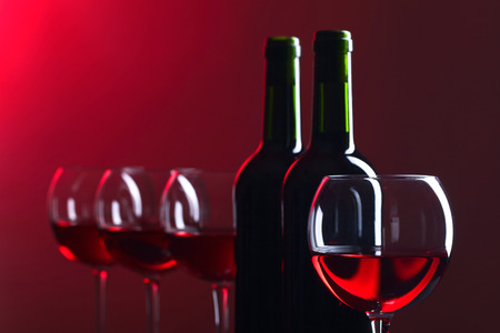 Bottles and glasses of red wine on a dark backgroundの写真素材
