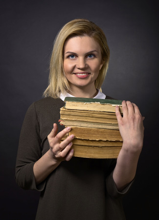 Portrait of young happy woman with old books .の写真素材