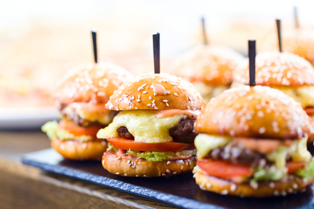Burgers stuffed with delicious toppings on wooden table in restaurant .Selective focus .