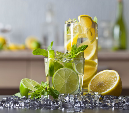 Cocktails with lime , lemon , ice and peppermint leaves on a black table .の写真素材