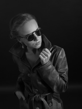 Portrait of beautiful woman in leather coat and sunglasses. Beautiful blonde with perfect hair and professional  make-up in retro stile .の写真素材