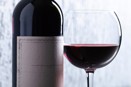 Bottle and glass of red wine . Old paper label . Copy space .の写真素材