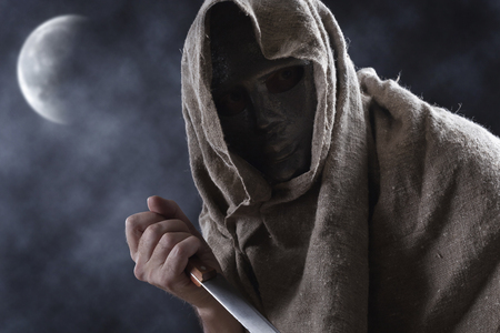 Man in iron mask with a big knife in his hand  ,  Halloween concept.の写真素材