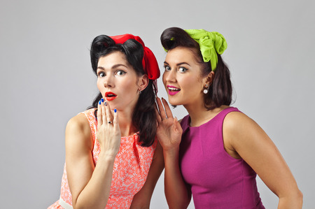 Beautiful women talking .Girls in pin up style with perfect hair and make up .Expressive facial expressions.の写真素材