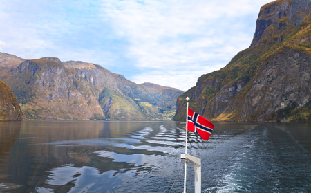 Scenic landscapes of the northern Norwegian fjords.Beautiful view of the coast of Sognefjord on a september day. Focus on a flag.の写真素材