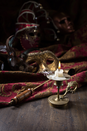 Old brass candlestick and masquerade Venetian carnival masks .の写真素材