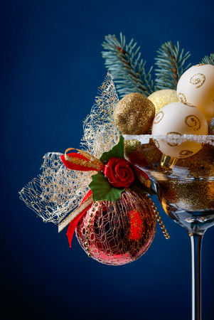 Christmas balls in wineglass on a dark blue background. の写真素材