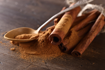 cinnamon sticks and powder on a old wooden tableの写真素材