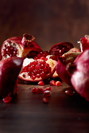 Ripe pomegranate on a old wooden table. Selective focus. Copy space .の写真素材
