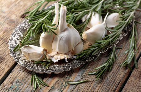 Rosemary and garlic on a old wooden table.の写真素材
