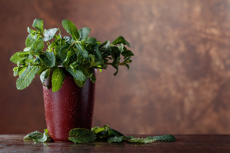 Bunch of fresh green organic mint on old wooden table.の写真素材