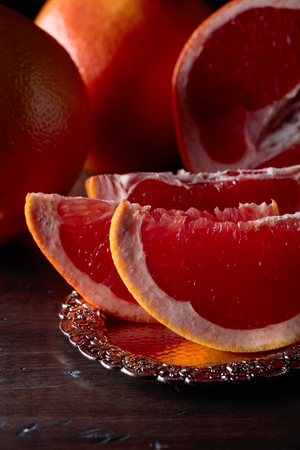 Slices of fresh ripe grapefruit on old wooden table.の写真素材