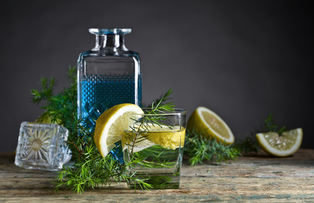 Cocktail with blue gin , tonic and lemon on a old wooden table . の写真素材
