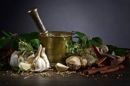 Different herbs and spices on a old wooden table . 