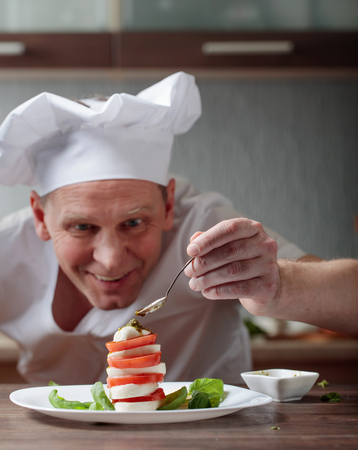 Chef prepares a snack with mozzarella and pesto sauce . Selective focus .の写真素材