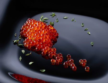 Red caviar on a black plate. Healthy organic food.の写真素材