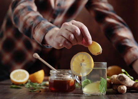 Cup of ginger tea with honey , lemon and mint on old wooden table .  Selective focus .の写真素材