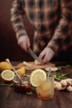 Cup of ginger tea with honey , lemon and mint on old wooden table .  Selective focus .の写真素材