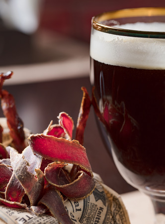 Closeup of homemade American beef jerky with cold beer.