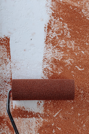 Painting roller  surface copper paint  inside in apartment close up. Painting over rough plaster . Repair In house. Copy space, top view.の写真素材