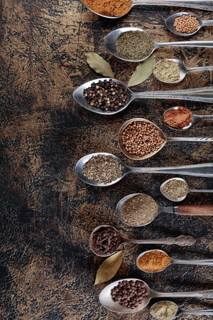Different spices in  spoons on a vintage background. Copy space for your text.Top view.の写真素材