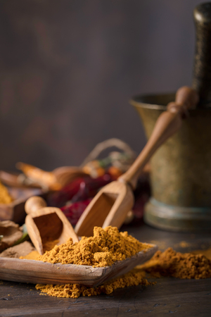 Various Indian spices with wooden spoons on a old wooden table, copy space for  your content.の写真素材