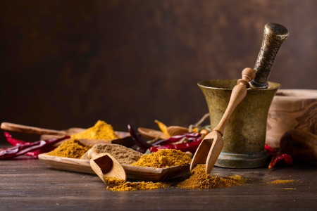 Various Indian spices with wooden spoons on a old wooden table, copy space for  your content.の写真素材