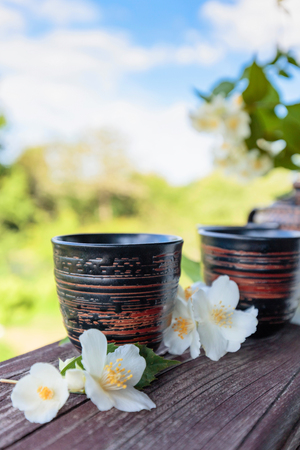 Jasmine tea in small ceramic cups on old wooden table in garden . Copy space.の写真素材