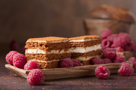 Homemade layered honey cake with cream and red raspberries.の写真素材