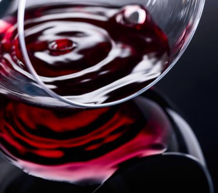 Glass of red wine, macro shot , black reflective background.の写真素材