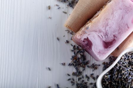 Bar of natural organic soap with lavender on white wooden background. Handmade soap making. Spa products and skin care concept. Copy space.の写真素材