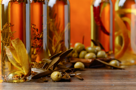 Green olives and bottles of olive oil with spices and herbs. Selective focus.の写真素材