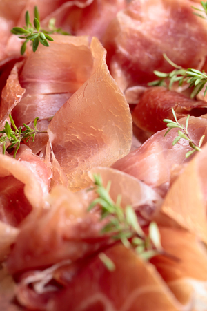Italian prosciutto crudo or jamon with thyme on a metal platter .の写真素材
