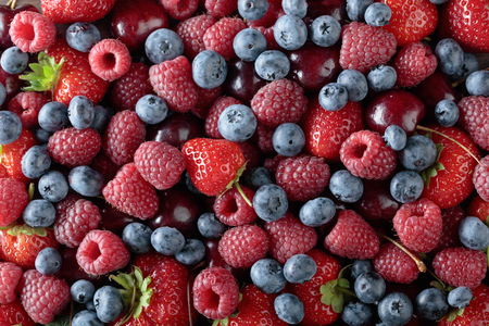 Berries closeup colorful assorted mix of strawberry, blueberry, raspberry and sweet cherry .