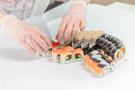 Restaurant  staff in rubber gloves lays the table with seafood.の写真素材